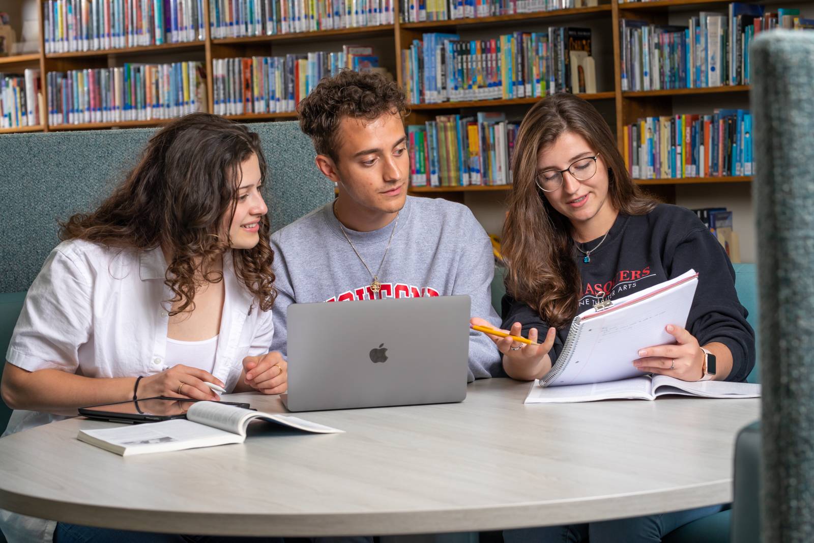 Three students studying at the library