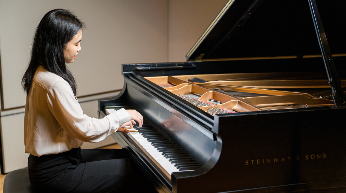 Student performs on a grand piano.